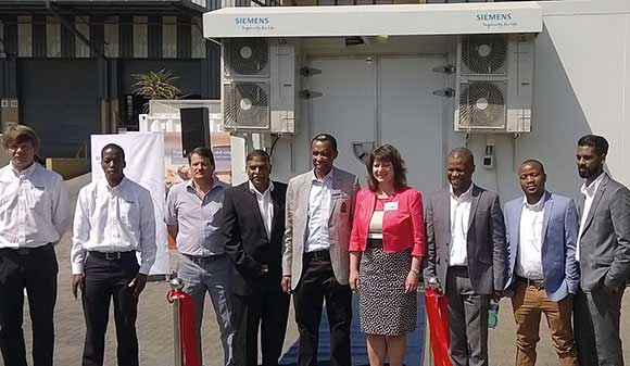 The ribbon cutting party with the substation in the background. 